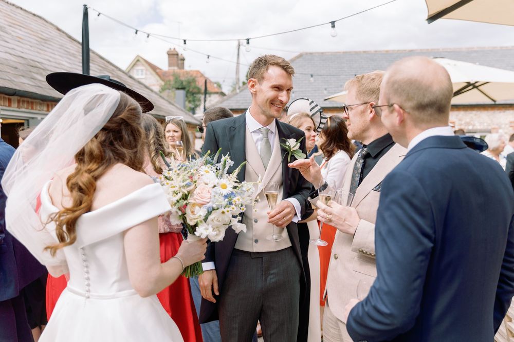 Wedding guests celebrate outdoors under string lights during a festive outdoor reception party.