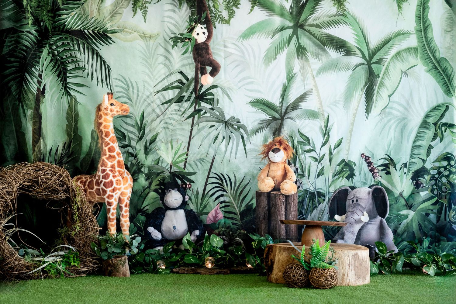 Stuffed animal toys arranged in a jungle-themed setting with palm trees and greenery backdrop. Suitable for Smash & Splash photography.