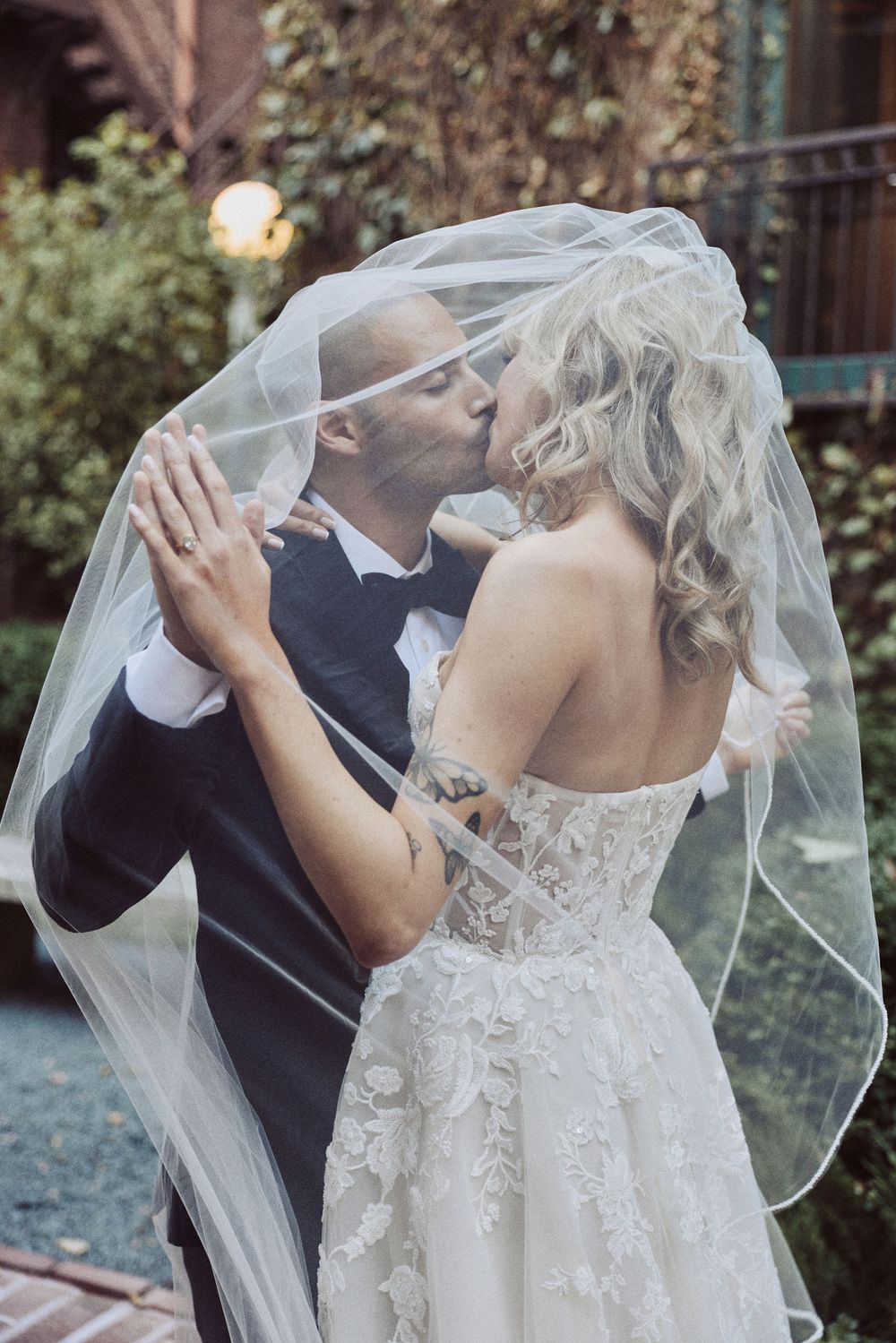 A romantic wedding photo series showing a couple in an intimate dip pose with the bride's veil flowing in the breeze.