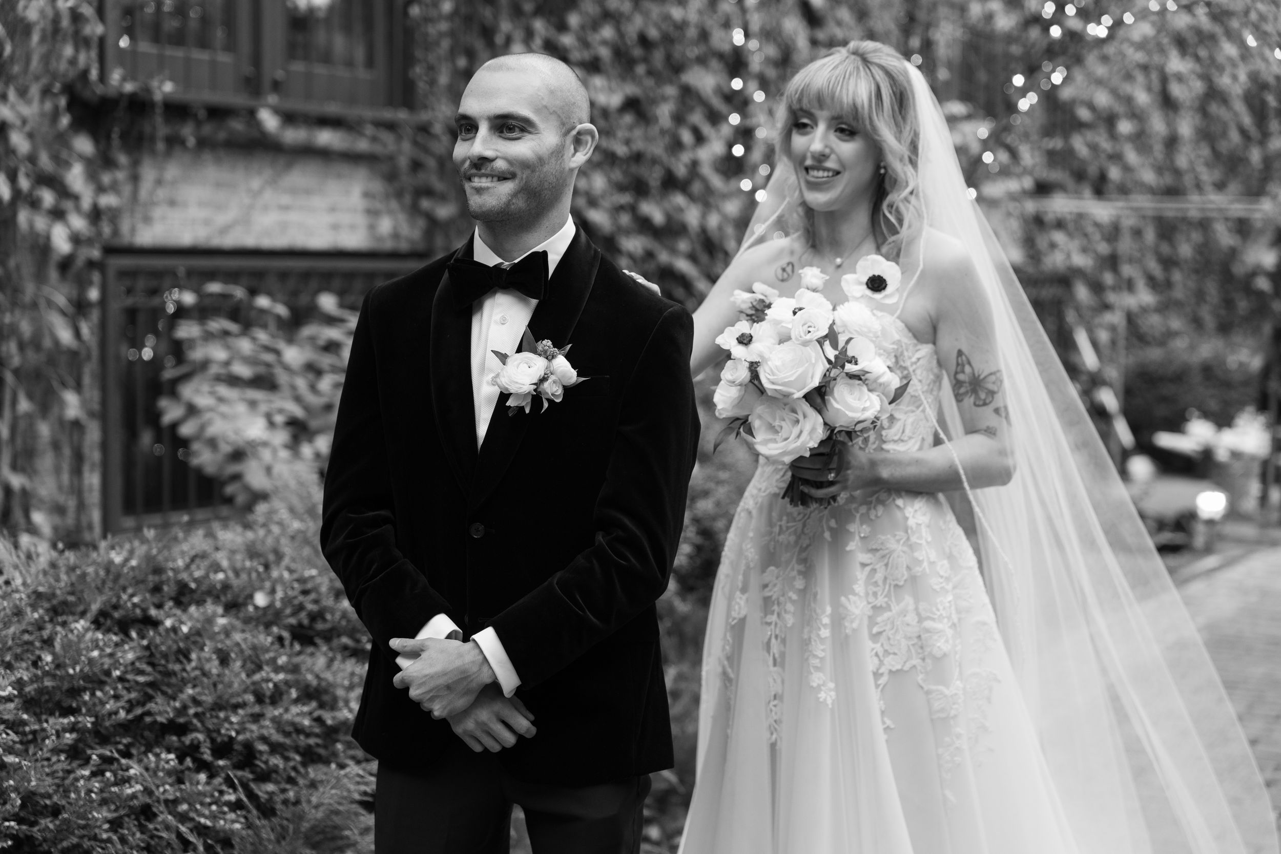 A bride and groom share an intimate moment in a garden setting during their wedding celebration.