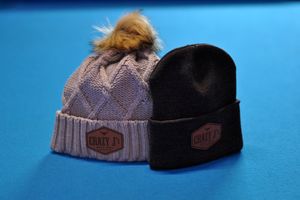 Collection of knit winter beanies displayed on a blue background.