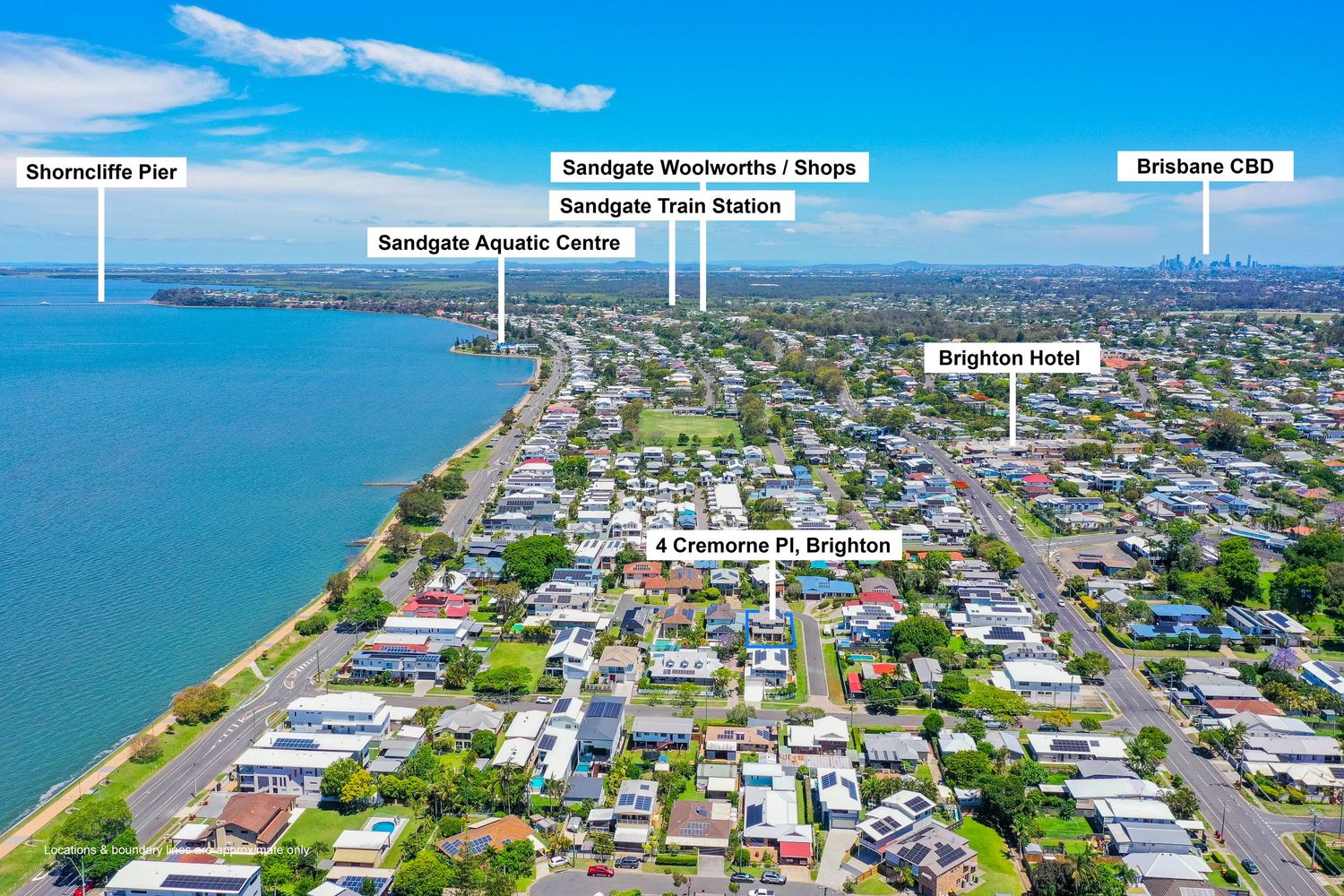Aerial view of Brighton suburb near Sandgate showing shops, train station, aquatic centre, and Brisbane CBD.