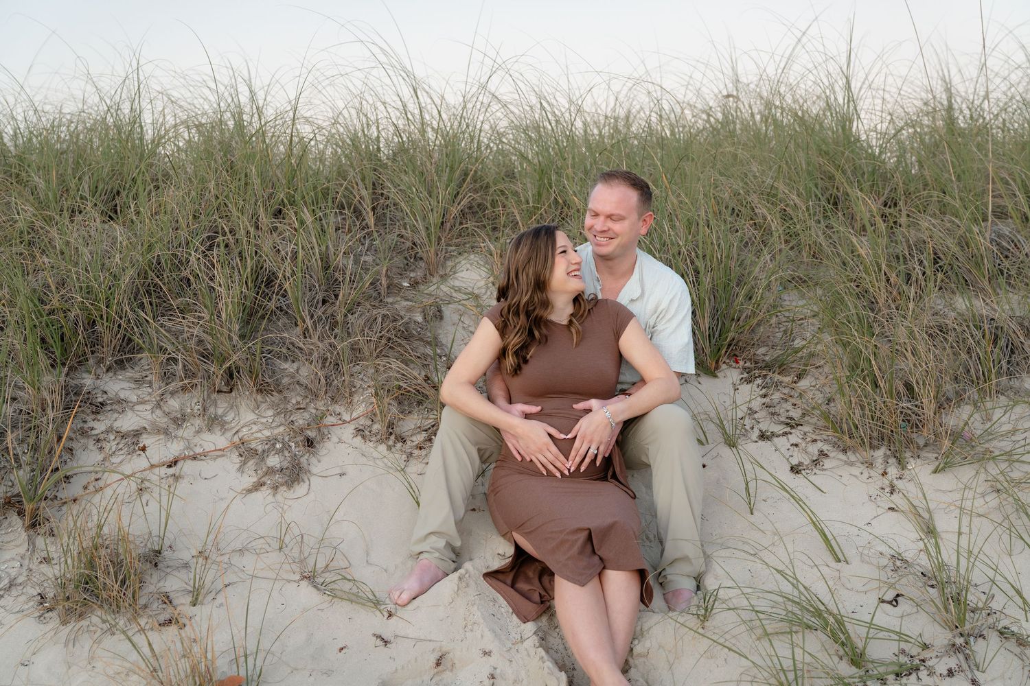 A group of candid beach portraits showing people sitting and relaxing in sand dunes with tall grass at sunset.