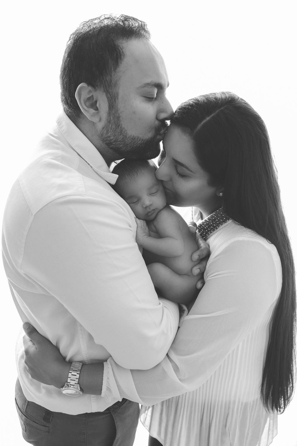 Black and white series of romantic couple embracing and sharing intimate moments in white clothing.