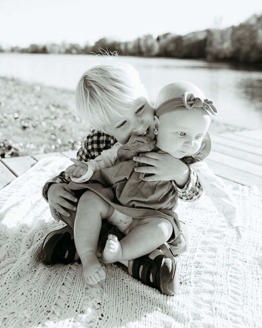 Black and white image of people embracing on a textured white surface. Lakeside family photo session. Central Michigan family photos