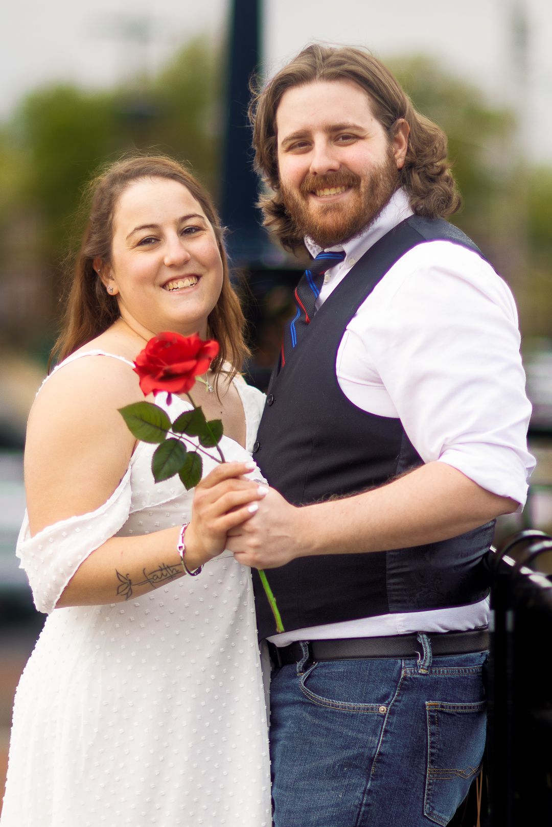 A couple in wedding attire share romantic moments while holding a red rose in a series of outdoor portraits.