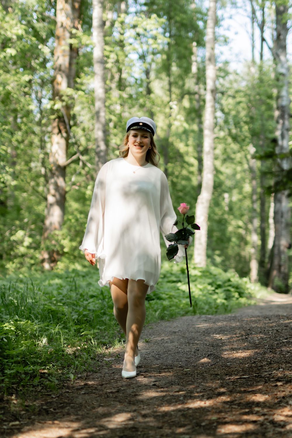 Ylioppilas kävelee metsässä kauniin ruusun kanssa, potretti