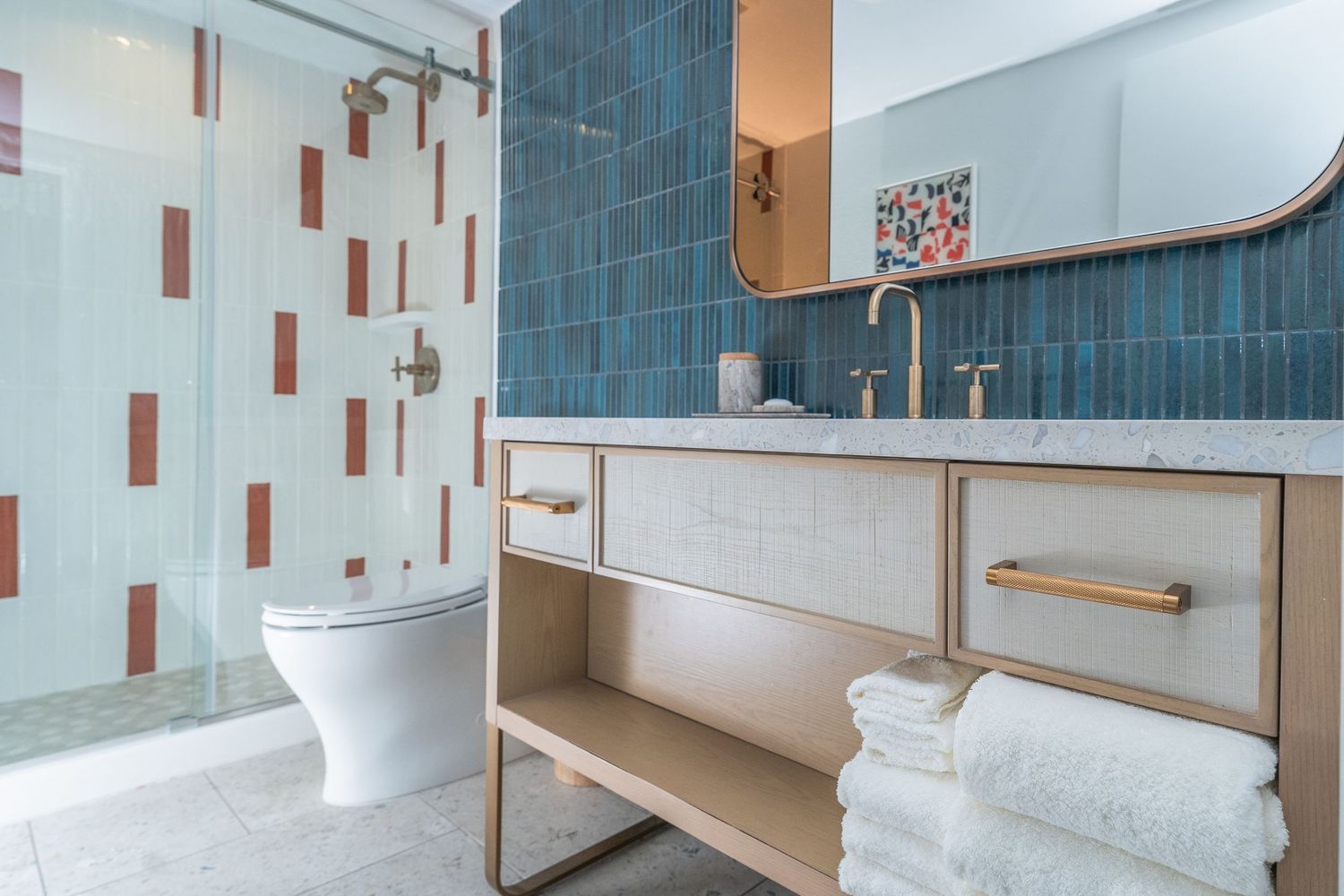 Modern bathroom interior with blue tile walls, white fixtures, and sleek minimalist design elements.