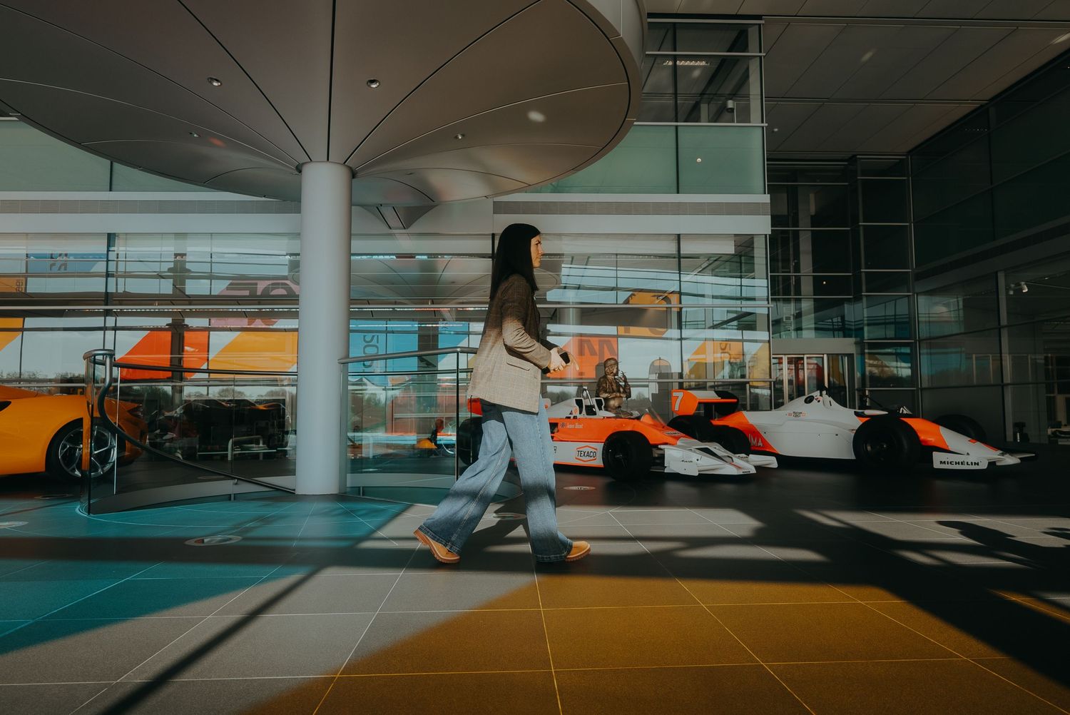 Modern parking garage interior with orange and teal lighting creates a dramatic architectural perspective.
