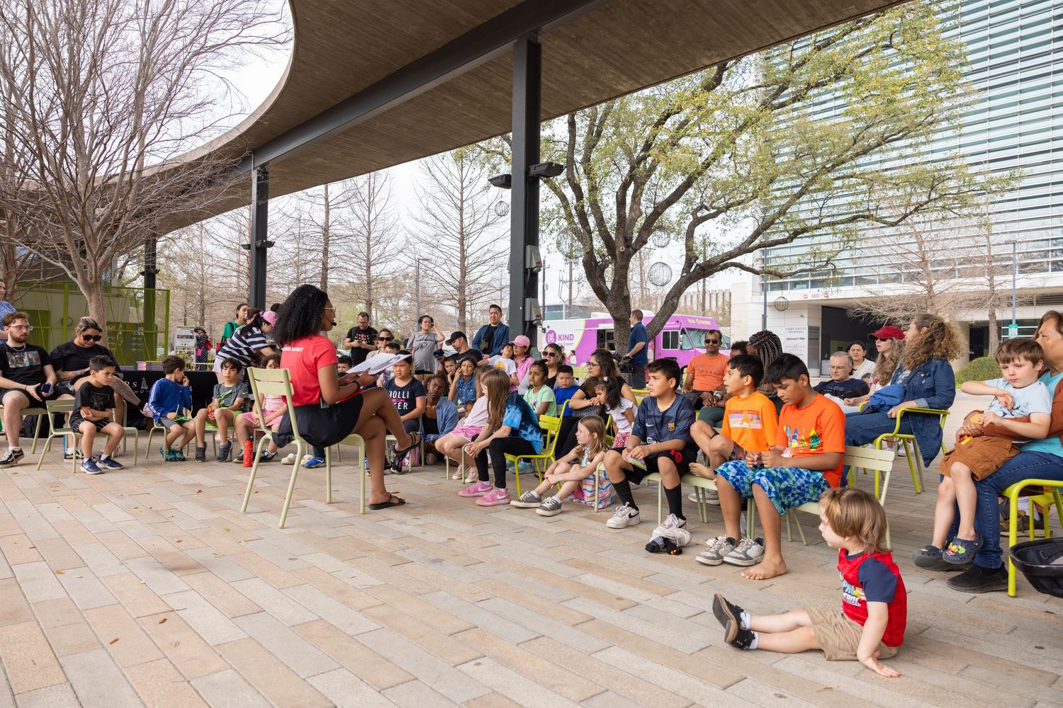 A group of people gather outside a building for a fitness class or training session in cold weather.