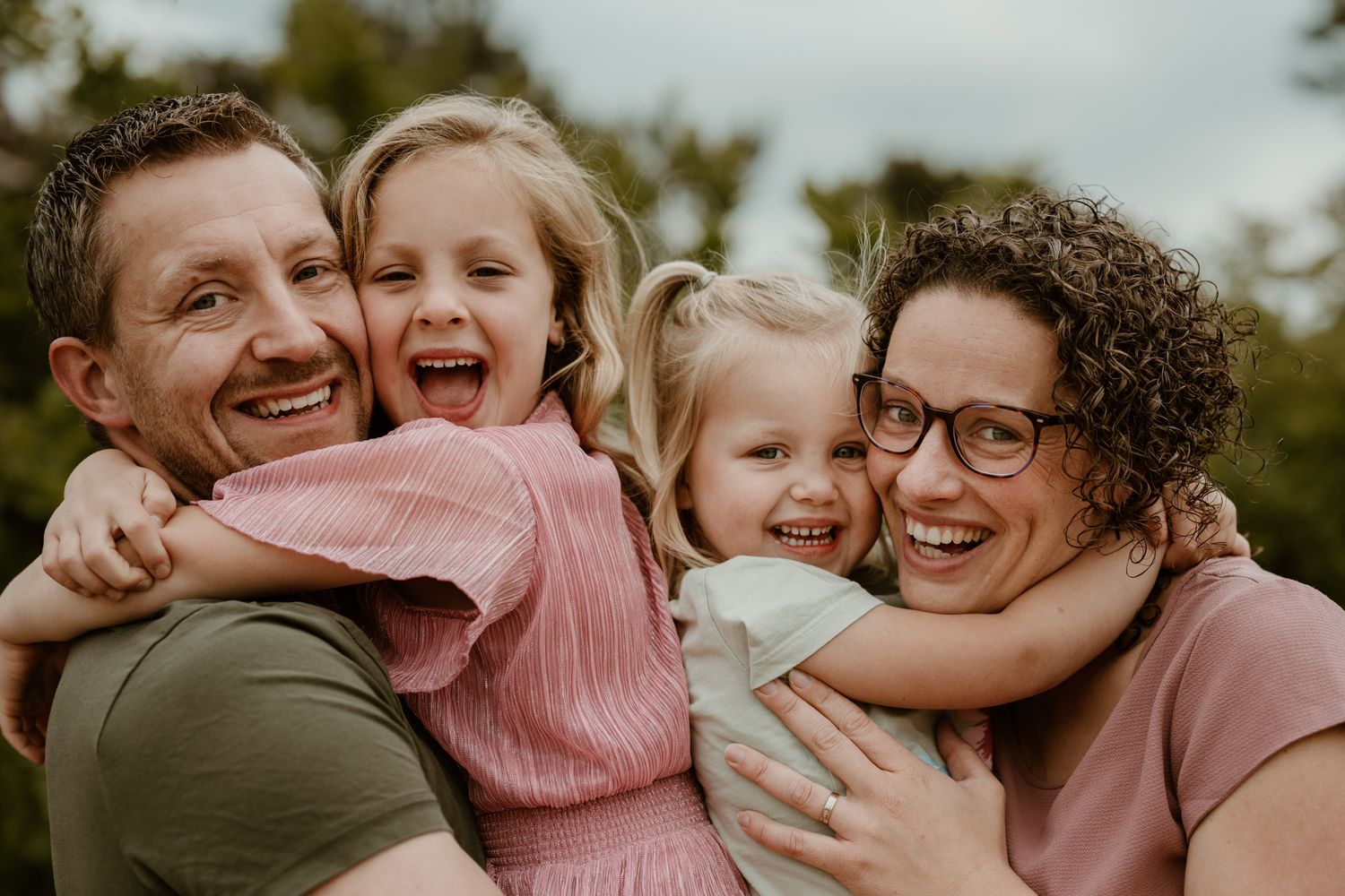 Gezinsshoot in Assen, Drenthe. Ontspannen kinderen tijdens een rustige fotoshoot knuffelen met hun ouders