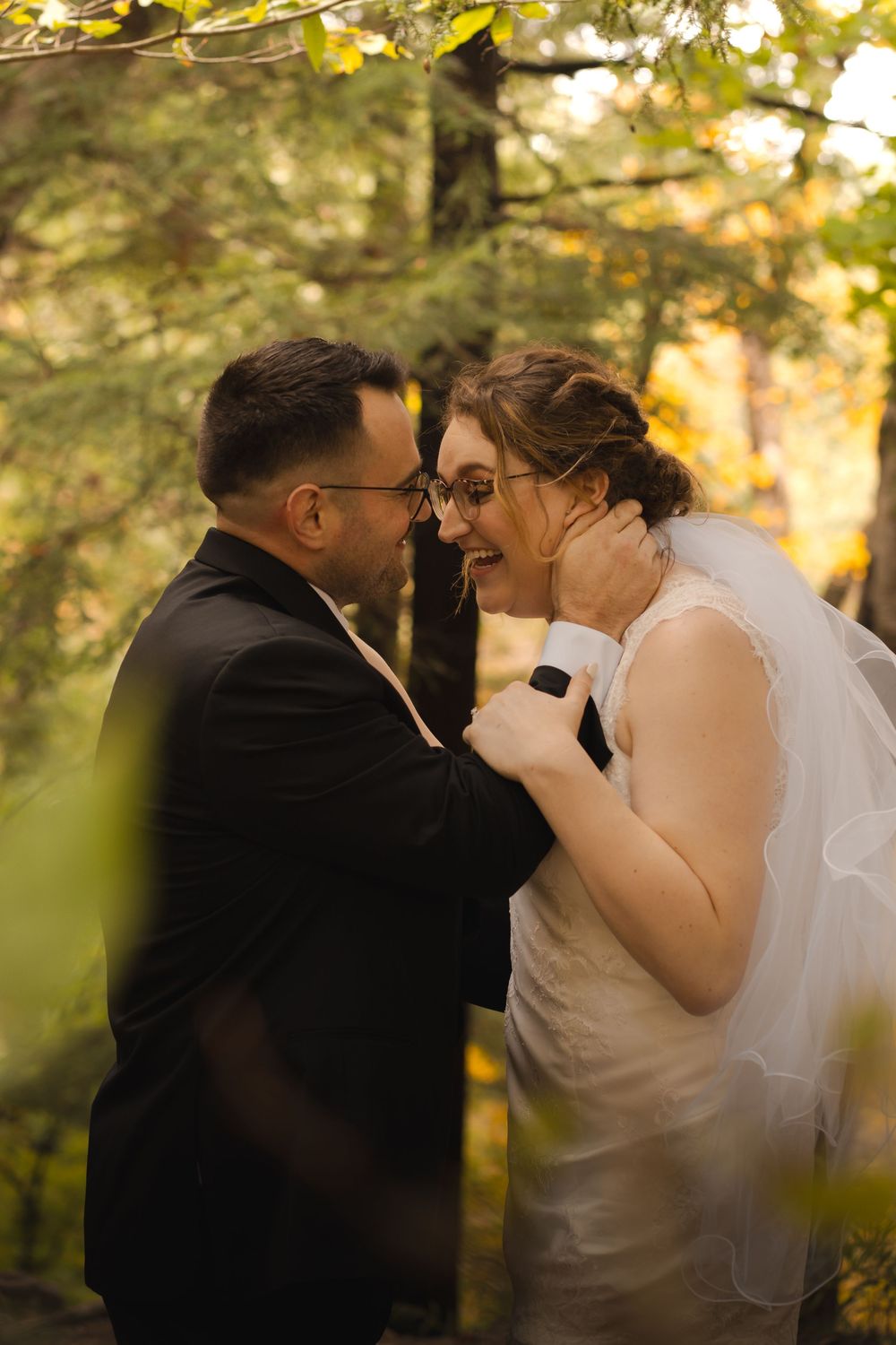 A romantic wedding couple shares intimate moments in a sunlit forest setting during golden hour.