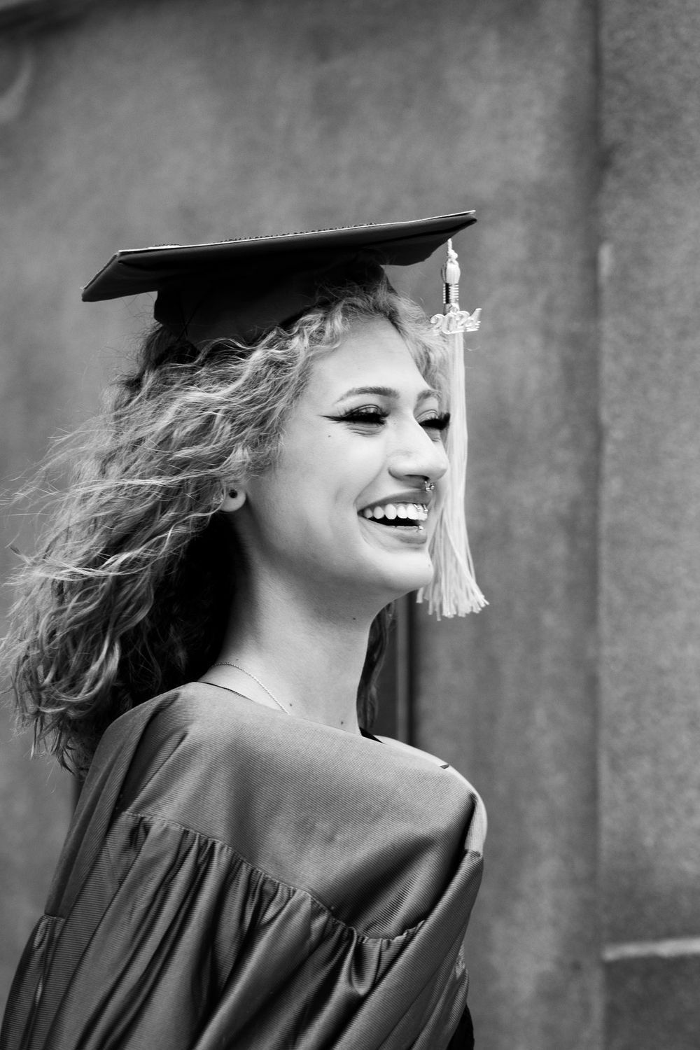A black and white photo series showing a graduate in cap and tassel laughing and moving with joy during a celebration.
