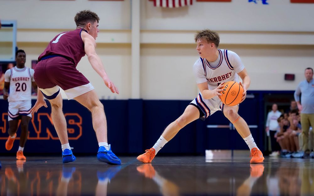 Trojans guard dribbles past a New Oxford defender, focused on the play during quarterfinals by SportsFox Photography, Hershey PA.