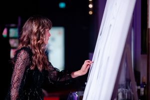 A dimly lit performance stage with dramatic red and purple lighting creates an atmospheric ambiance.