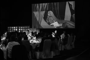 Dark silhouettes of guests mingling at an evening reception.