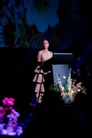 A stage performance with dramatic blue lighting and floral arrangements.