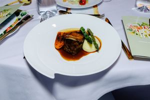 Elegant plated dishes with garnishes served at an upscale dining event.