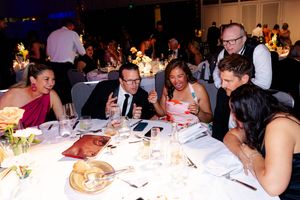 Guests seated at elegant dining tables during a formal evening event.