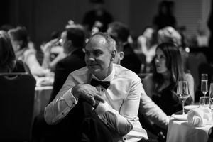 Black and white photo of guests dining at an elegant evening event.