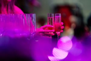 Abstract stage lighting creates vibrant pink and purple atmospheric effects.