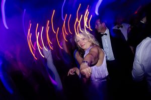 Nightclub scene with purple lighting and streaks of neon orange light trails creating dynamic motion effects.
