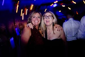 Party atmosphere at a nightclub with blue lighting and glowing neon accents.