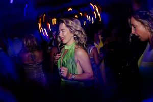 Nightclub scene with blue lighting and dancing crowd visible in the darkness.