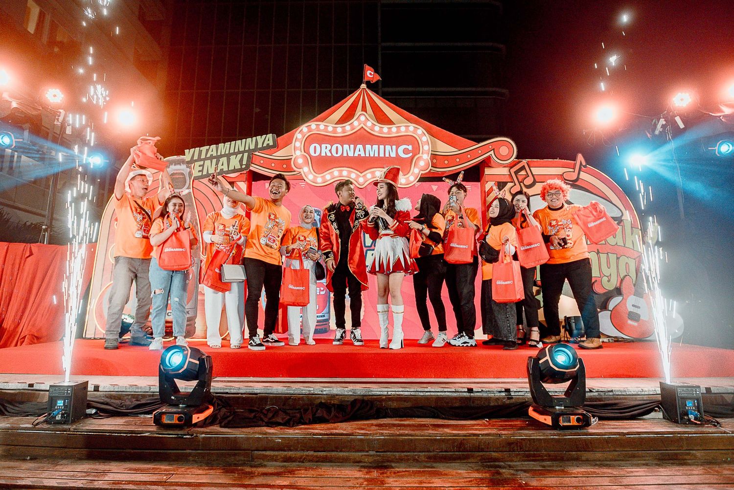 Performers on a brightly lit red stage create an energetic atmosphere during a live entertainment show.