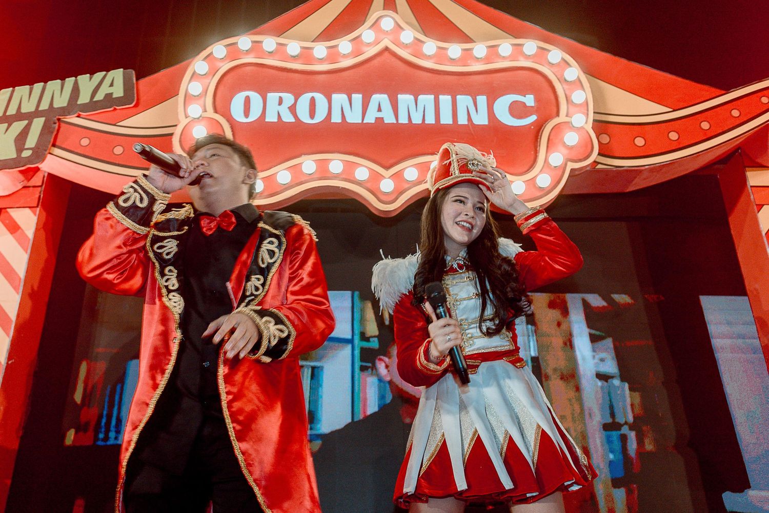 A red-lit circus-themed performance stage with spotlights and decorative elements creating a dramatic carnival atmosphere.