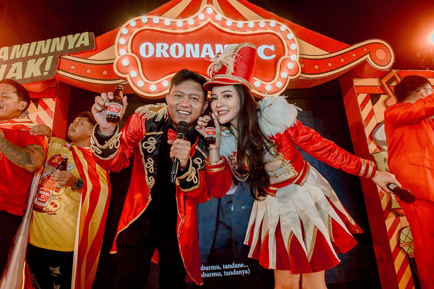 Group of people dancing and celebrating in red lighting at a festive party or nightclub event.