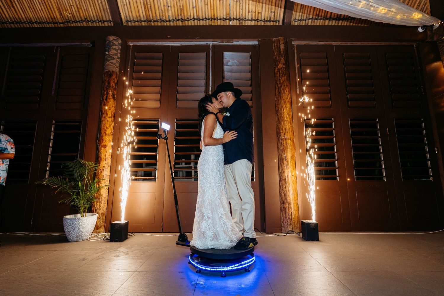 Modern wedding reception venue with LED dance floor and illuminated LOVE sign under purple and blue lighting.