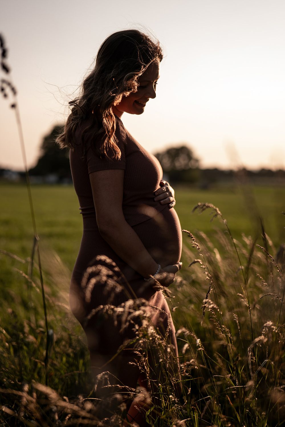 Silhouette einer schwangeren Frau im Gegenlicht während eines Shootings am Niederrhein