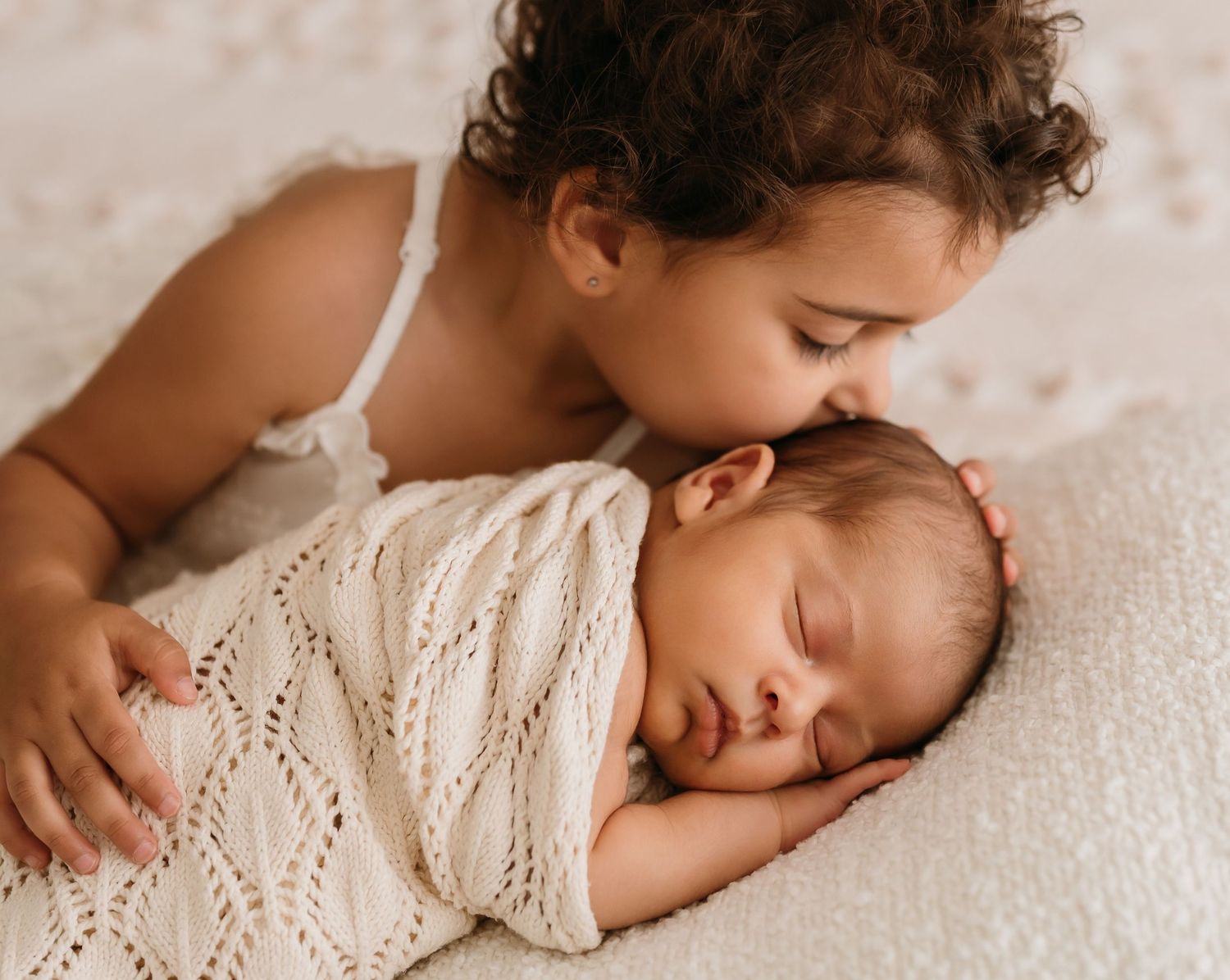 Toddler cuddling newborn baby brother in their home during and in-home newborn photoshoot in sydney