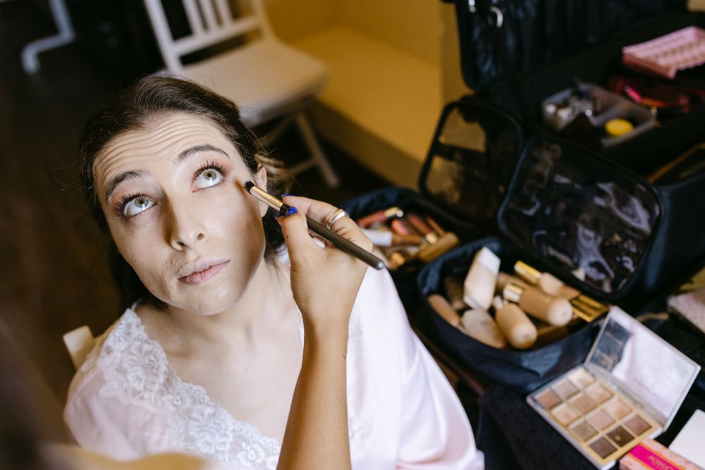 Makeup artist applying final touches before ceremony