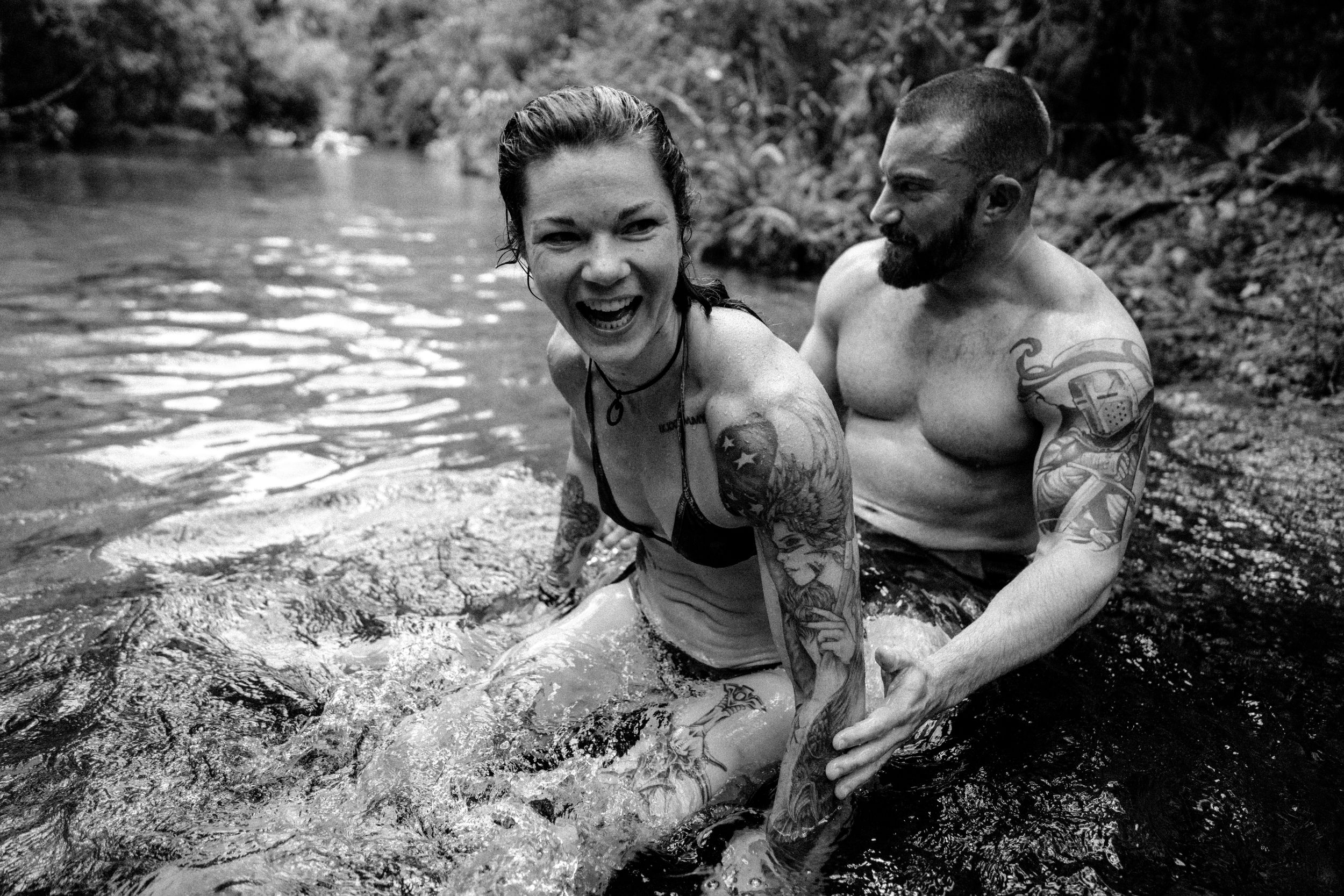 People enjoying a refreshing swim in a natural swimming hole on a summer day.