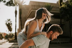 A couple embraces in a romantic outdoor photoshoot with warm lighting and natural scenery.