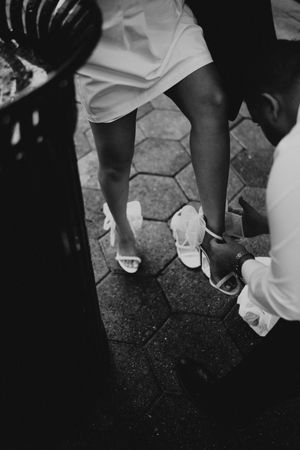Close-up view of feet in white shoes dancing on a dark surface.