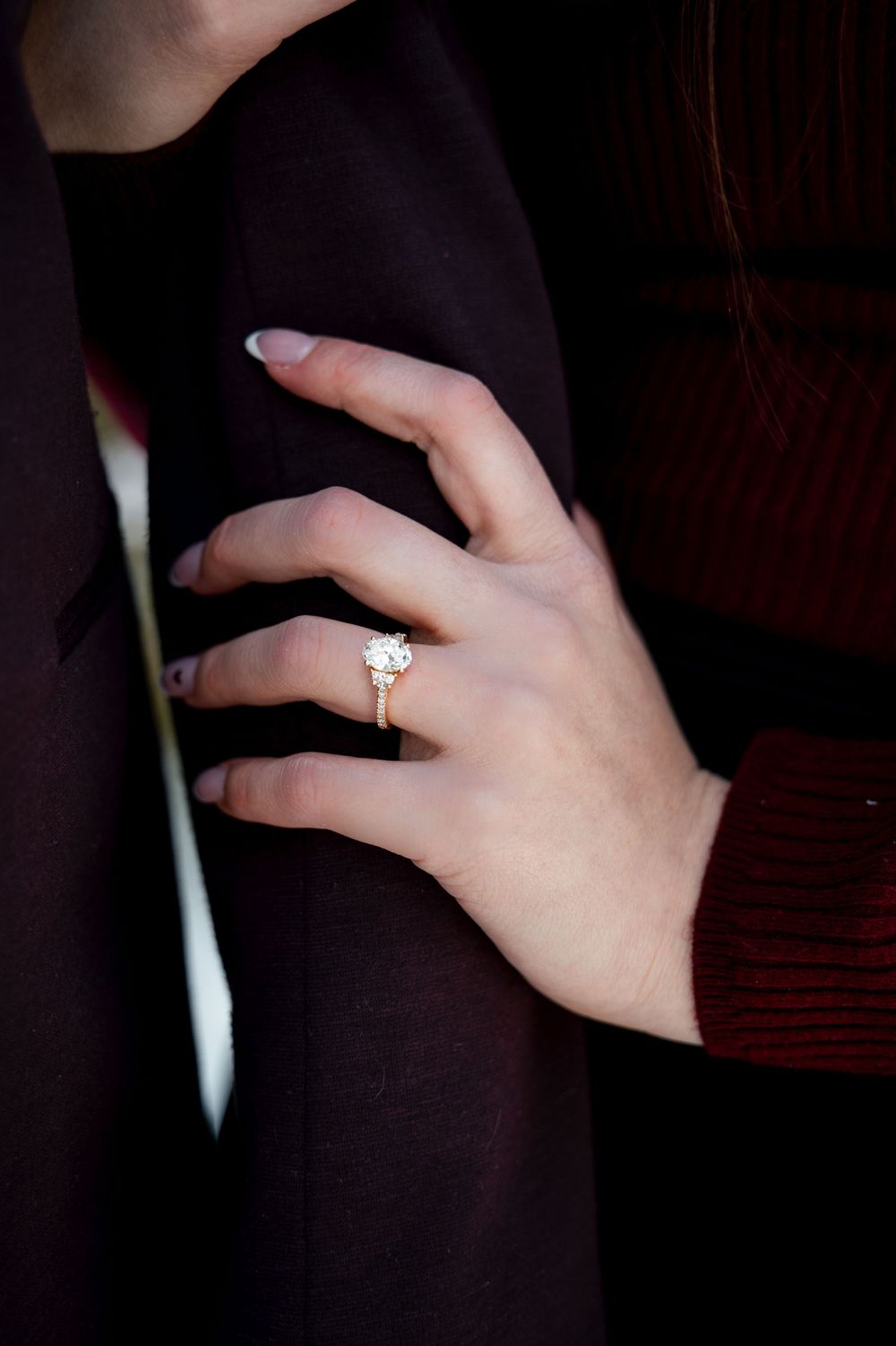 Close-up series of a sparkling diamond engagement ring on a hand against a dark background.