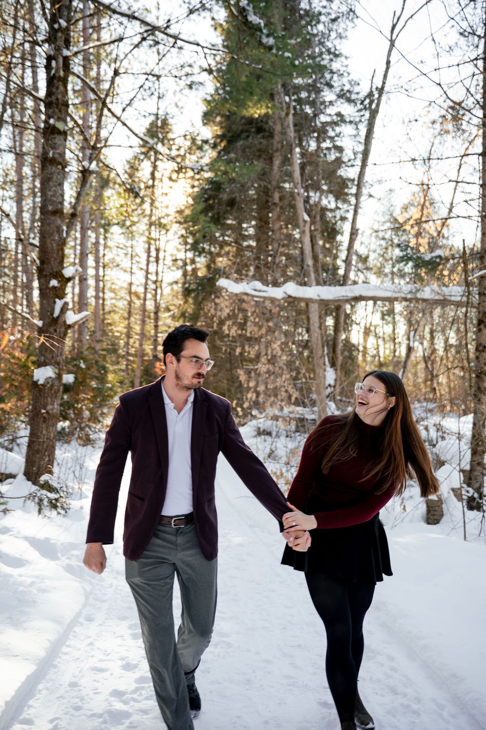 A playful winter photoshoot sequence in a snowy forest with warm sunlight filtering through the trees.