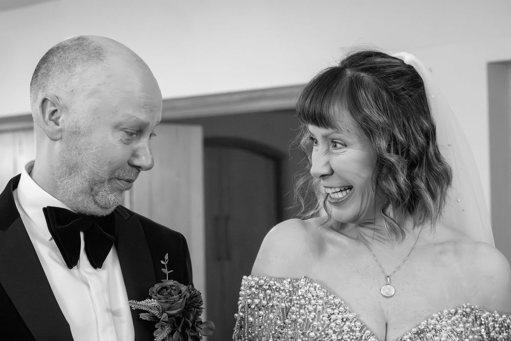 A collection of black and white wedding photos showing candid moments between the bride and groom.