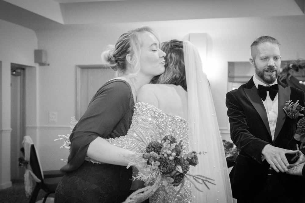 Black and white photo montage showing candid moments from an elegant wedding celebration with dancing and embraces.