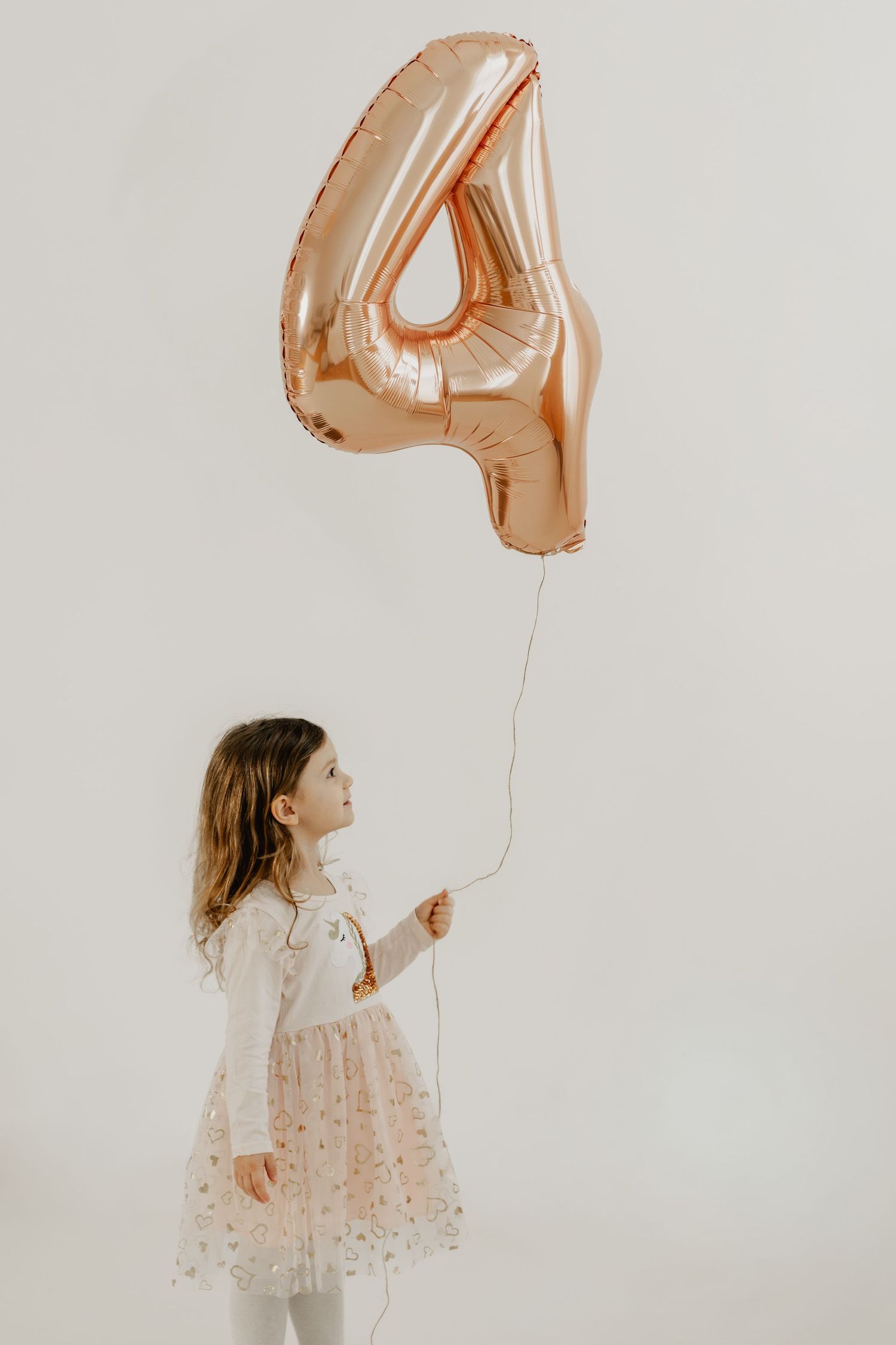 Geburtstagskind Mädchen mit Luftballonzahl 4 beim Geburtstagsfotoshooting in Stockerau im Fotostudio