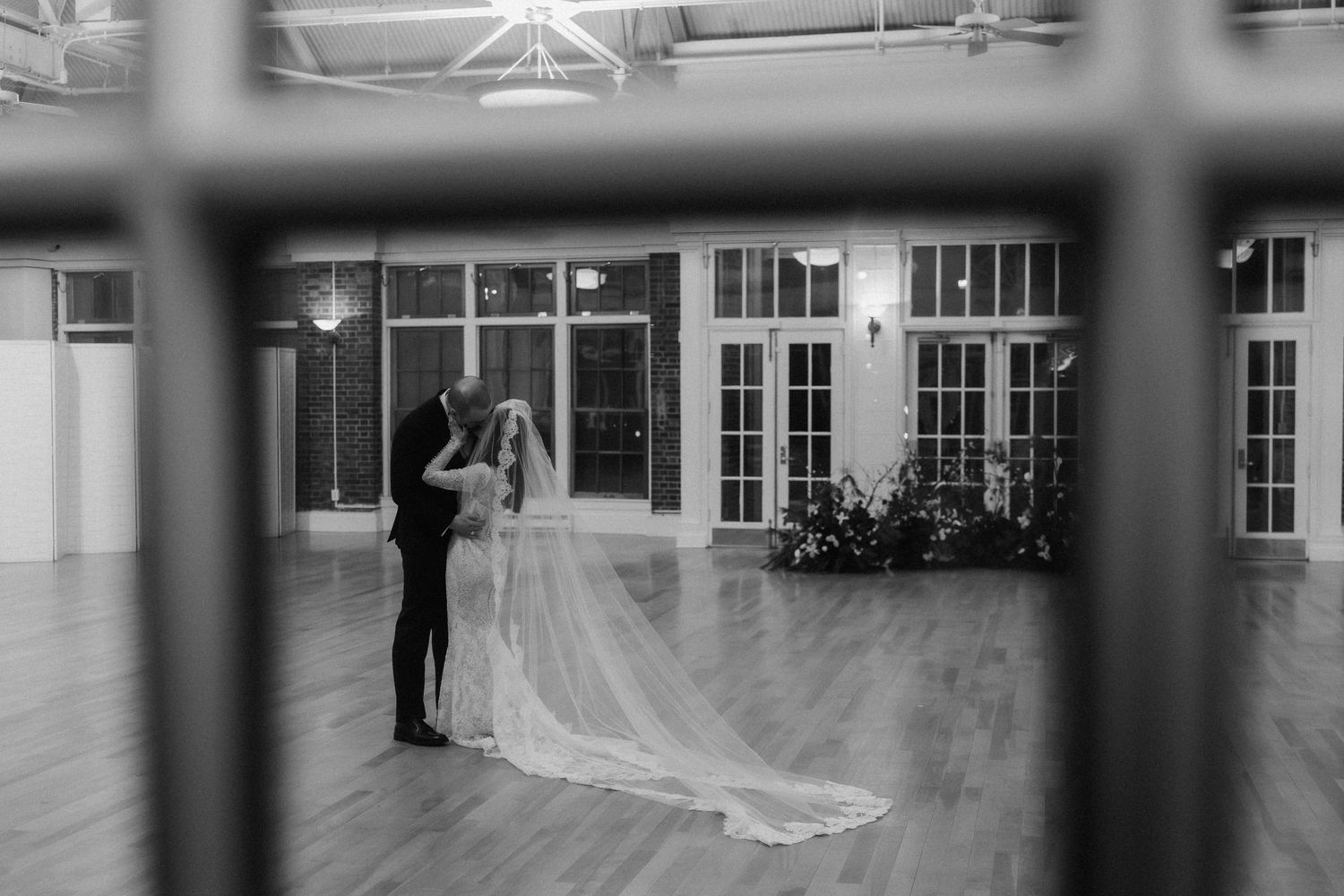 Dancers rehearsing in a large mirrored studio with natural light streaming through tall windows.