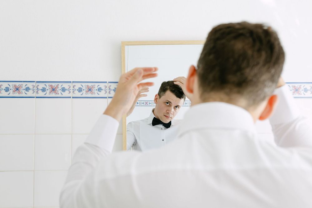 groom doing his hair at a wedding destination in lisbon