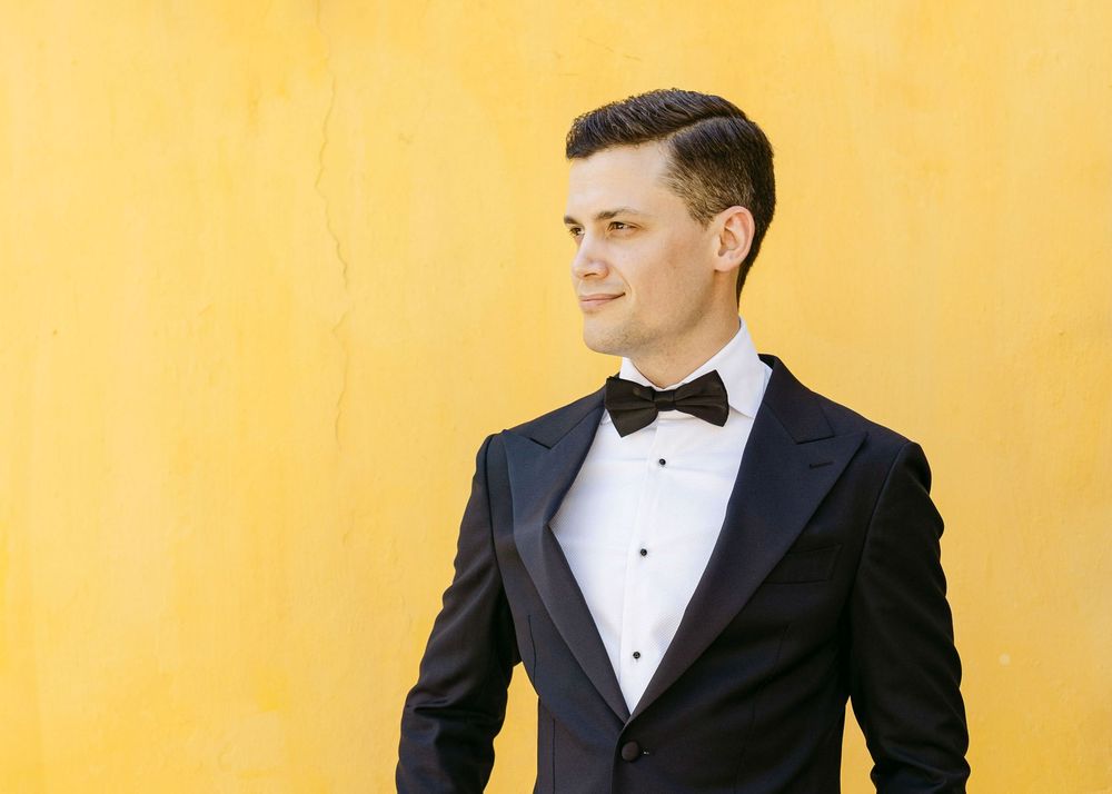 groom final portrait in front of a yellow outside wall at quinta nova do hespanhol