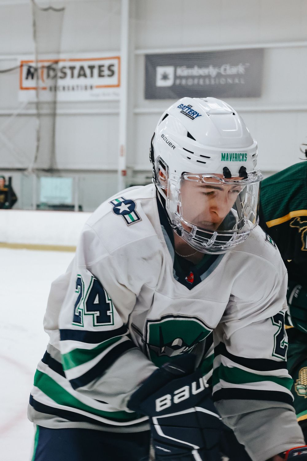Close-up action shot of hockey players in white jerseys during an intense game moment.