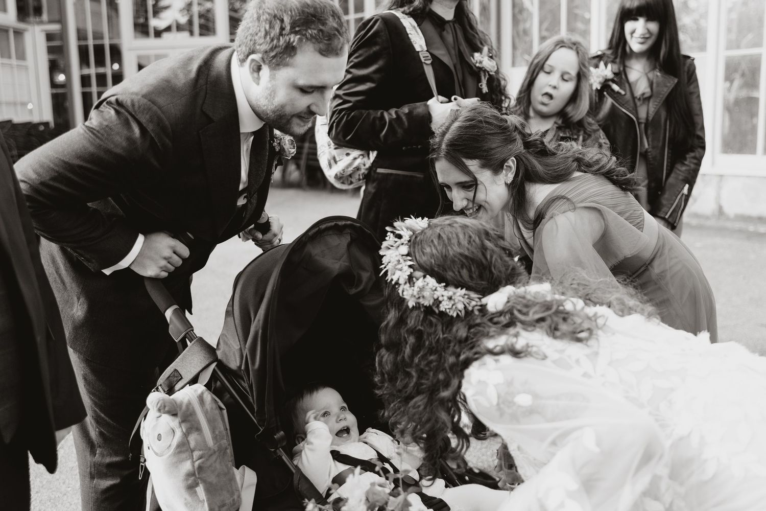 A group of people celebrate joyfully during a wedding reception, sharing laughter and candid moments together.