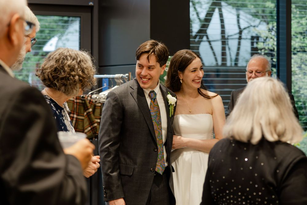 Newlyweds share a joyful moment with guests during an indoor wedding reception.