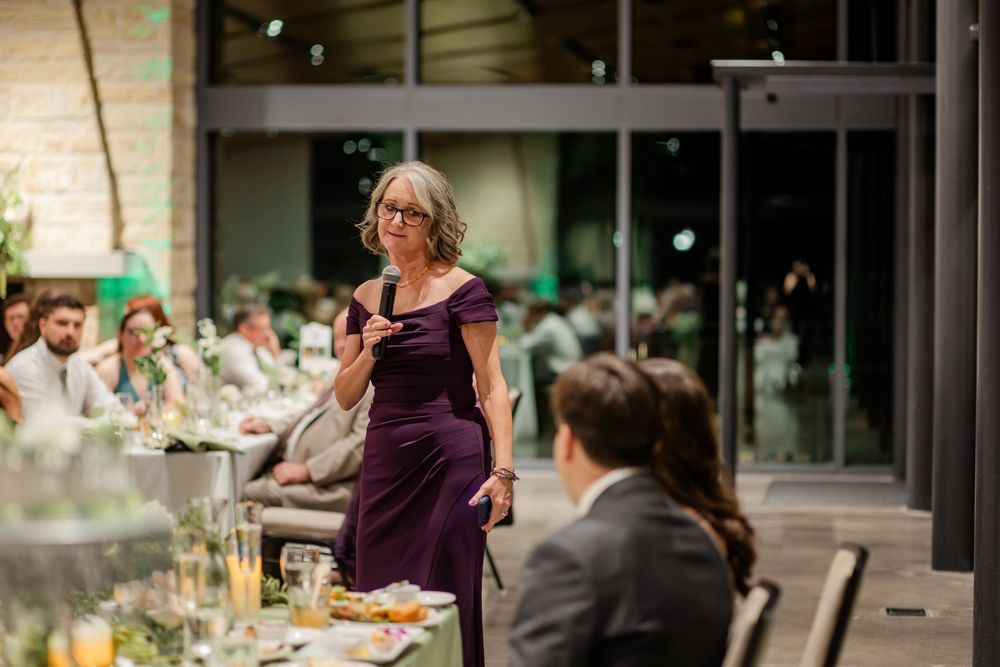 Guests mingle and dine at an elegant outdoor reception with tables set under string lights.